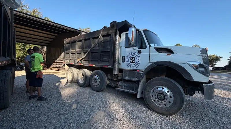 Streamline Construction dump truck with the crew at a job