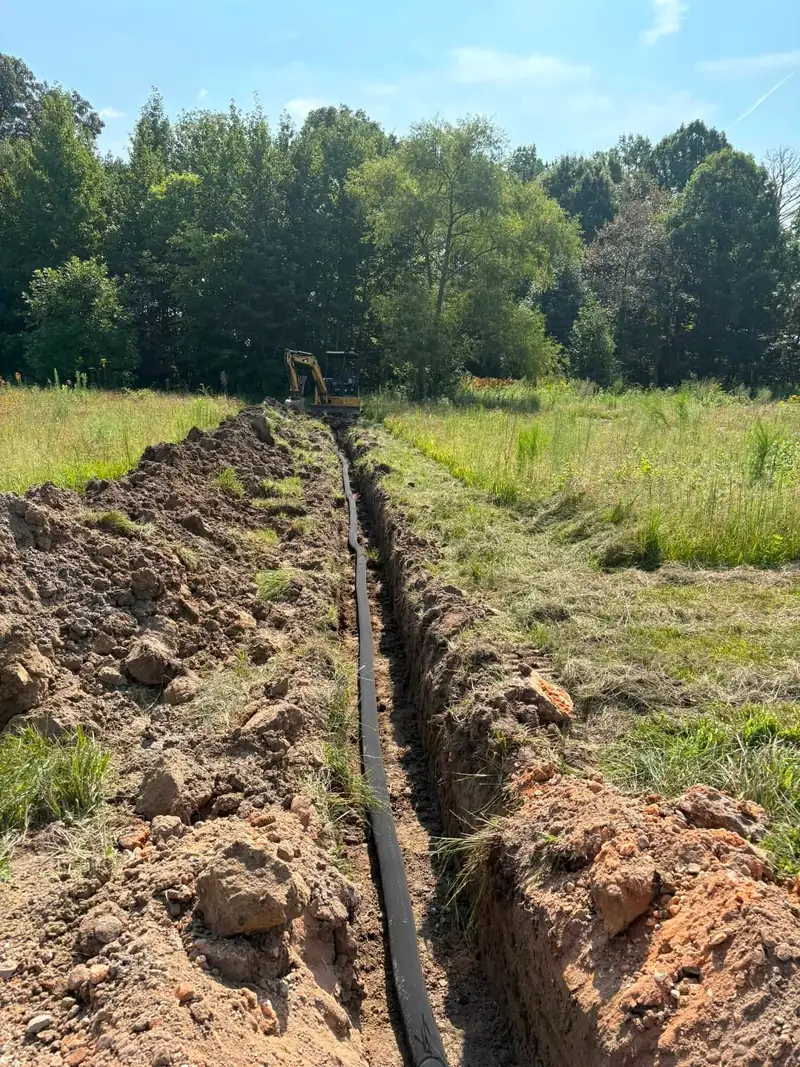 French drain trench dug across a field