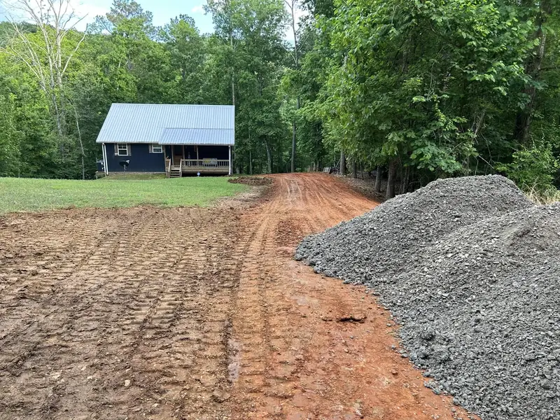 Stone delivered and spreading on a cabin driveway