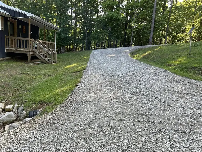 Curved gravel driveway beside a cabin