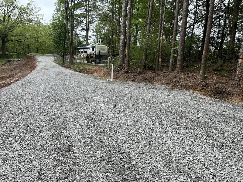 New gravel driveway through a wooded lot