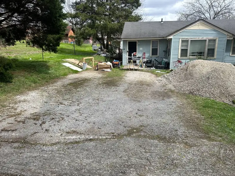 Worn, uneven gravel driveway before regrading