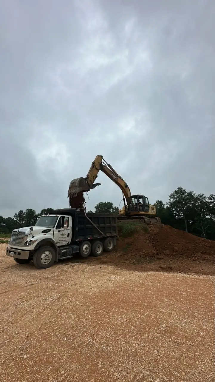 Excavator loading tri axle dump truck